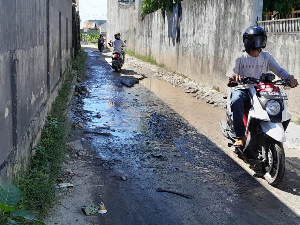 Kondisi Jalan siswa terdapat kubangan di ujung jalan yang menyebabkan becek meski tak ada hujan di kawasan itu. (F: Syahrin Ayahu/Gorontalo Post)