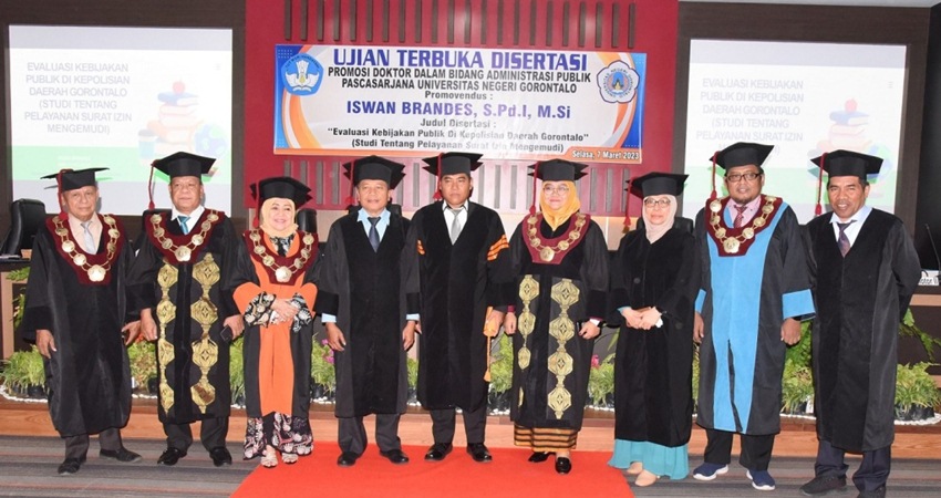 BIKIN BANGGA : IPTU Iswan Brandes, berhak menyadang gelar doktor, setelah berhasil mempertahankan disertasi di hadapan penguji pada ujian terbuka disertasi di UNG, Selasa (7/3). (foto : dok / UNG)