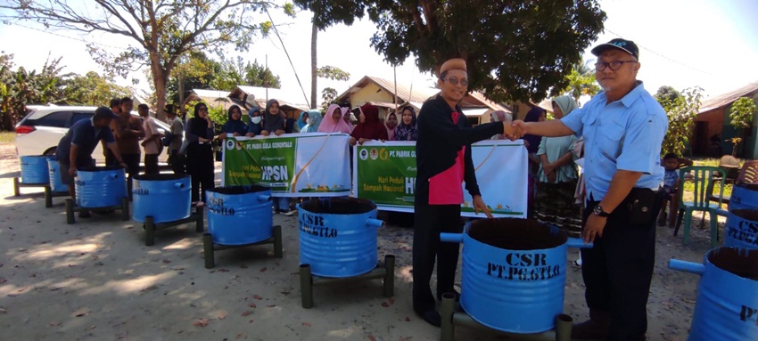 Pimpinan PT PG Gorontalo diwakili Quality Control Laboratory (QCL Manager) Alaq Setoadji, ST saat menyerahkan tong sampah kepada Kepala Desa Gandaria Samin Rahman SPd yang merupakan bantuan untuk masyarakat. (Foto: Roy/Gorontalo Post).