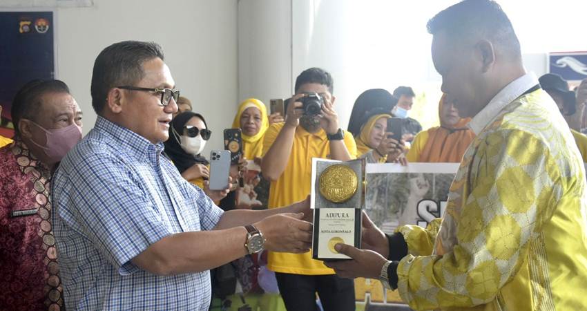 Wali Kota Gorontalo, Marten Taha, ketika menyerahkan penghargaan Adipura kepada Kepala DLH Kota Gorontalo, Andris Amir, Jumat (3/3/2023). (Foto: Prokopim)