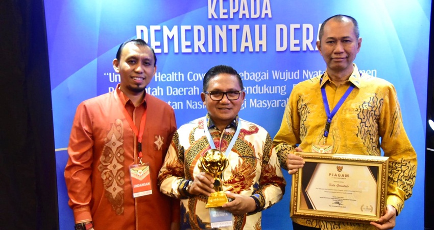 Wali Kota Gorontalo, Marten Taha didampingi Kepala Dikes Kota Gorontalo, Muhammad Kasim tengah menggenggam penghargaan UHC award yang diraih Pemerintah Kota Gorontalo, Selasa (14/3/2023). (Foto: Prokopim)
