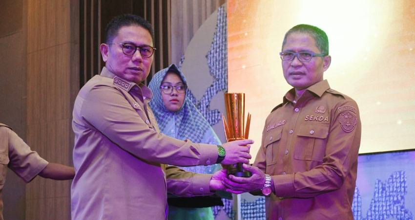 Sekda Ismail Madjid ketika menerima penghargaan terbaik pertama penyusunan perencanaan pembangunan se-Provinsi Gorontalo yang diserahkan Penjagub Gorontalo, Hamka Hendra Noer, Senin (10/4). (Foto: Prokopim)