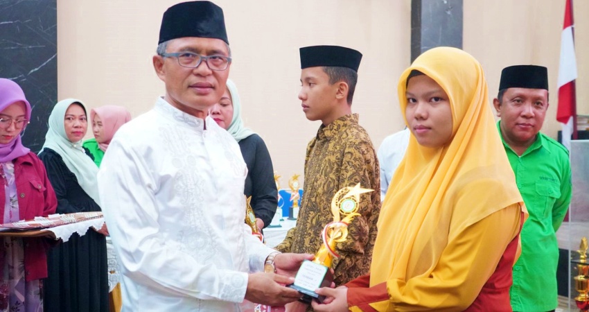 Sekda Kota Gorontalo, Ismail Madjid menyerahkan hadiah kepada salah satu peraih juara pada ajang STQH tingkat Kota Gorontalo. Penyerahan dilakukan usai acara penutupan STQH, Sabtu (13/5/2023). (Foto: Prokopim)