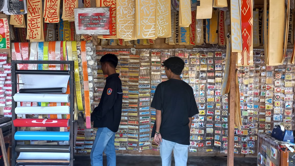 Pembeli saat sedang melihat stiker yang dijual di Jalan HB Jassin, Kota Gorontalo. (Foto Atika)
