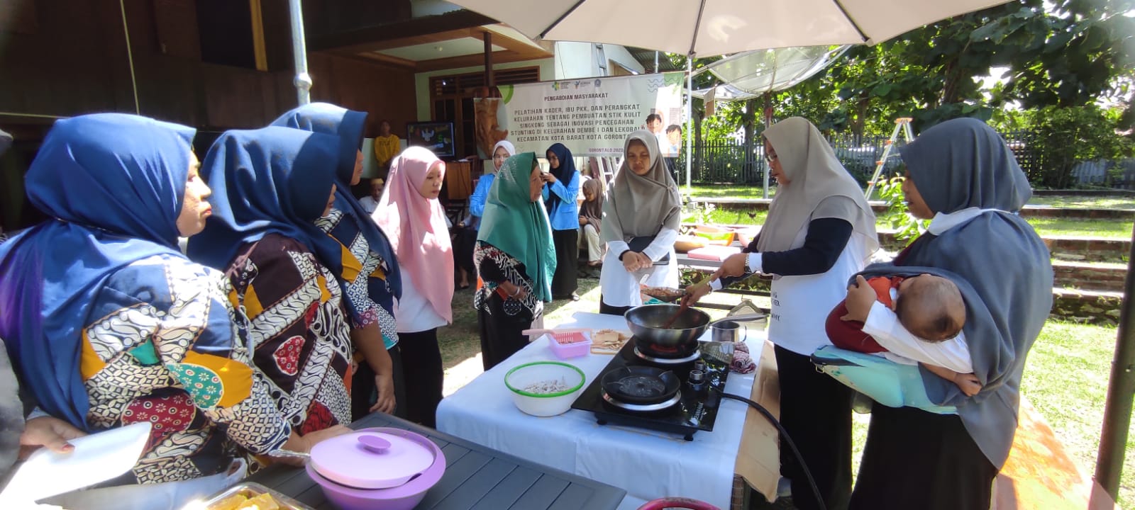 Ketua Tim Pengabdian Masyarakat yang juga dosen Poltekkes Gorontalo Magdalena M Tompunuh, S.ST, M.Pd saat mempraktekkan pembuatan Stik Kulit Singkong kepada warga Kelurahan Dembe I dan kelurahan Lekobalo, Rabu(24/5/23). Foto : Roy/Gorontalo Post