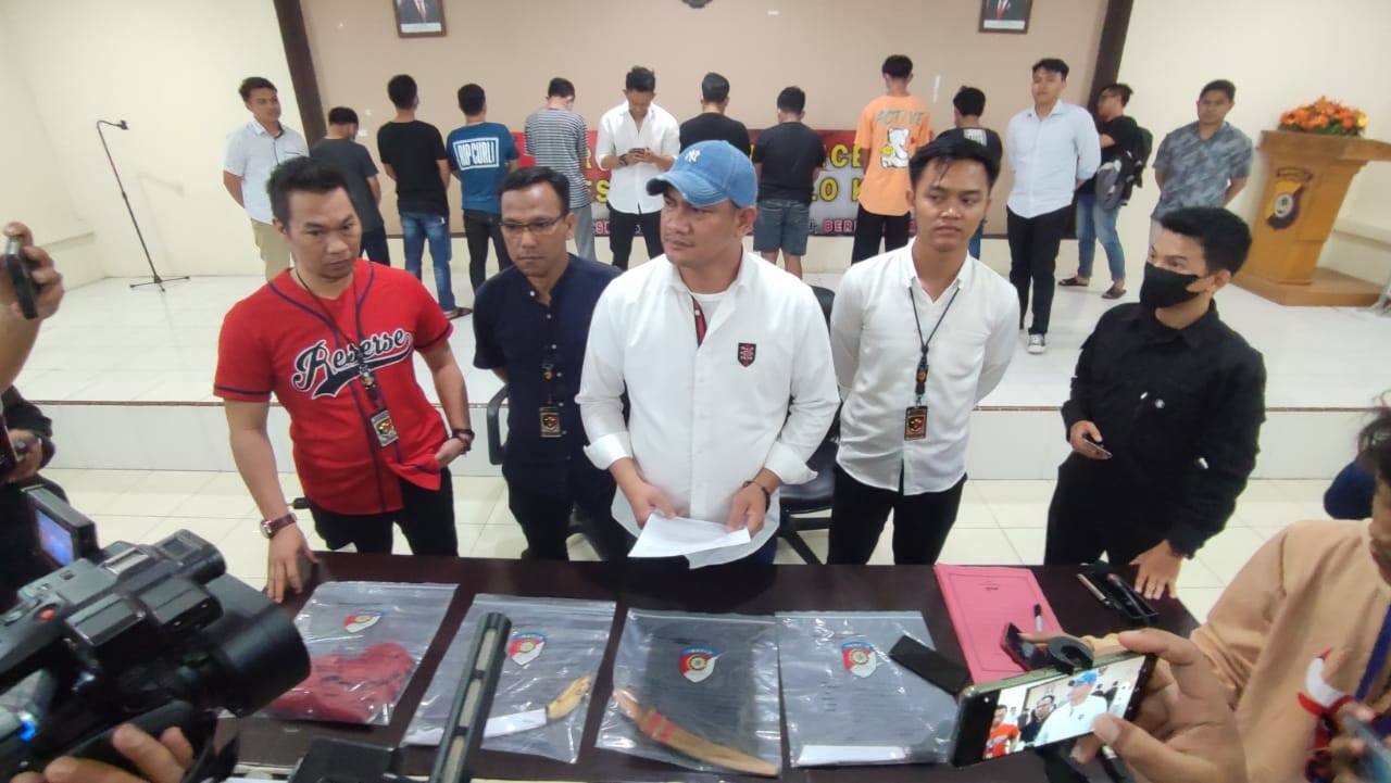 Sebelas tersangka dugaan pengeroyokan di Jl, HB Jasin Kota Gorontalo saat diamankan di Mapolres Gorontalo Kota. Kasat Reskrim Kompol Leonardo Widharta,S.I.K juga memperlihatkan barang bukti yang digunakan pelaku melakukan penganiayaan, Rabu (10/5/23). (Foto: Natha/Gorontalo Post)