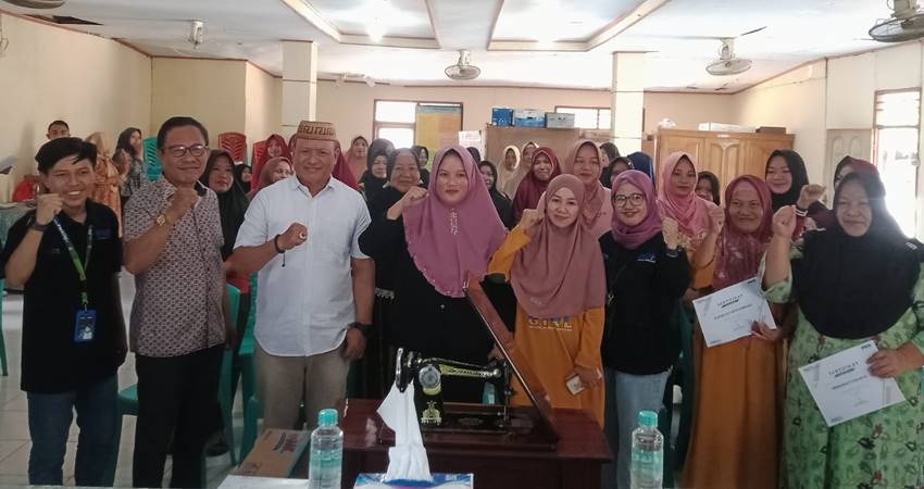 Kepala Diskumperindag Provinsi Gorontalo, Risjon Sunge saat berfoto sama dengan para nasabah PNM di Kantor Desa Molowahu, Kecamatan Tibawa Kabupaten Gorontalo, Sabtu (27/10) (F. Diyanti/Gorontalo Post)