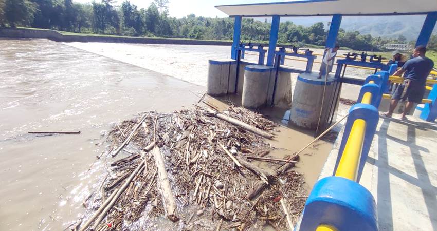 Sejumlah warga membersihkan sampah yang tersangkut di Bendungan Alale di Desa Lombongo Kecamatan Suwawa Timur, Bonbol. Akibat hujan yang turun beberapa hari ini. (F. Natha/Gorontalo Post)