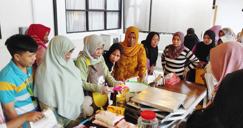 Salah satu nasabah PNM yang juga pelaku usaha kue kerawang Djamria Paputungan saat memperaktekan pembuatan kue kerawang kepada para nasabah lain saat kegiatan pengembangan kapasitas usaha program klasterisasi sektoral aneka kue kerawang, Jumat (8/12/23). (Foto: Roy/Gorontalo Post).
