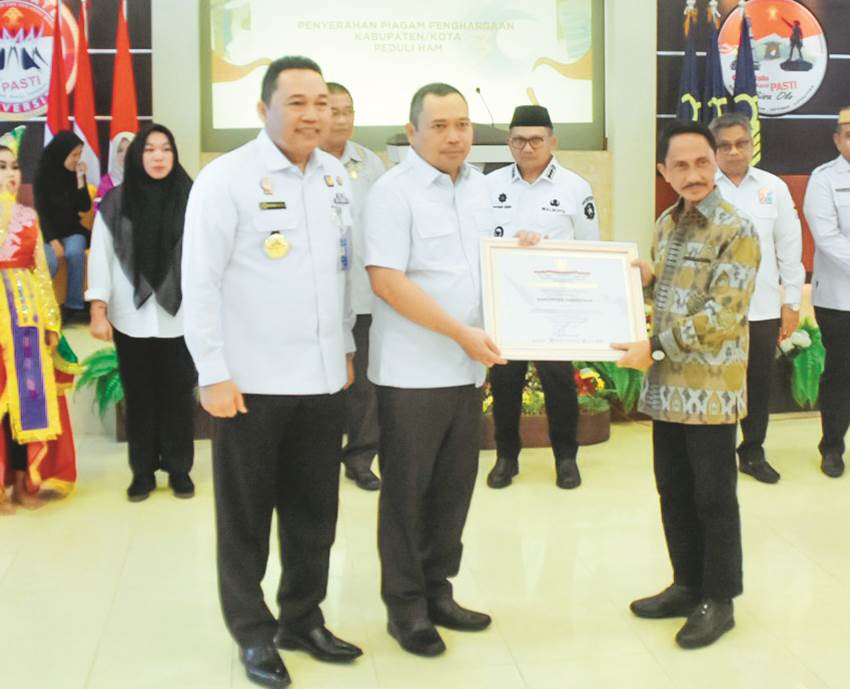 TERIMA. Bupati Gorontalo Nelson Pomalingo saat menerima penghargaan sebagai Kabupaten Peduli HAM, rabu (20/12).