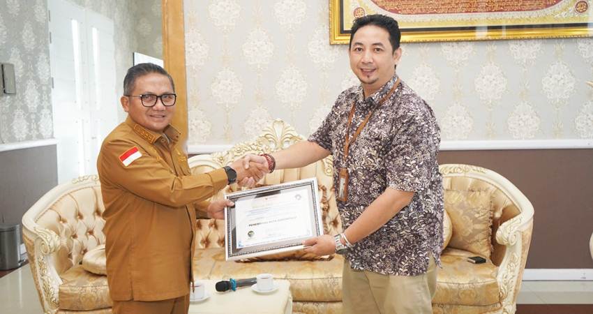 Wali Kota Gorontalo, Marten Taha, ketika menerima penghargaan atas pelayanan publik Pemerintah Kota Gorontalo tahun 2023 yang dinilai baik. Penghargaan diserahkan oleh Pjs Kepala Ombudsman RI Perwakilan Gorontalo, Wahyudin Mamonto, Selasa (30/1/2024). (Foto: Prokopim)