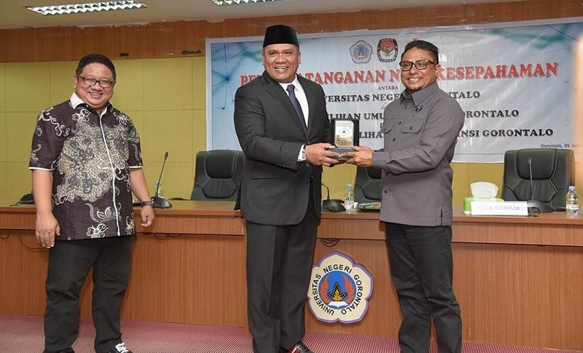 MBKM : Rektor UNG Prof. Eduart Wolok menyerahkan plakat logo UNG kepada Ketua Bawaslu Gorontalo saat penandatanganan kerjasama BMKM Pemilu, Selasa (9/1). (foto : dok / ung)