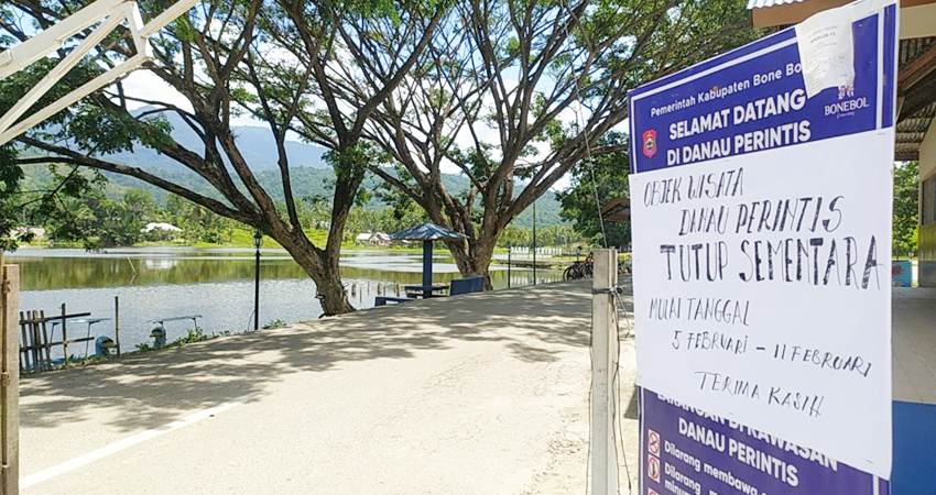 Portal pintu masuk objek wisata Danau Perintis dipasang baliho pemberitahuan informasi penutupan. (Foto Caisar/GP)