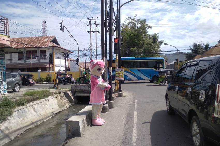 Salah satu badut yang beraksi di ruas jalan Jend. Sudirman Kota Gorontalo menunggu uluran tangan dari para pengendara kendaraan yang berhenti di traffic Light.