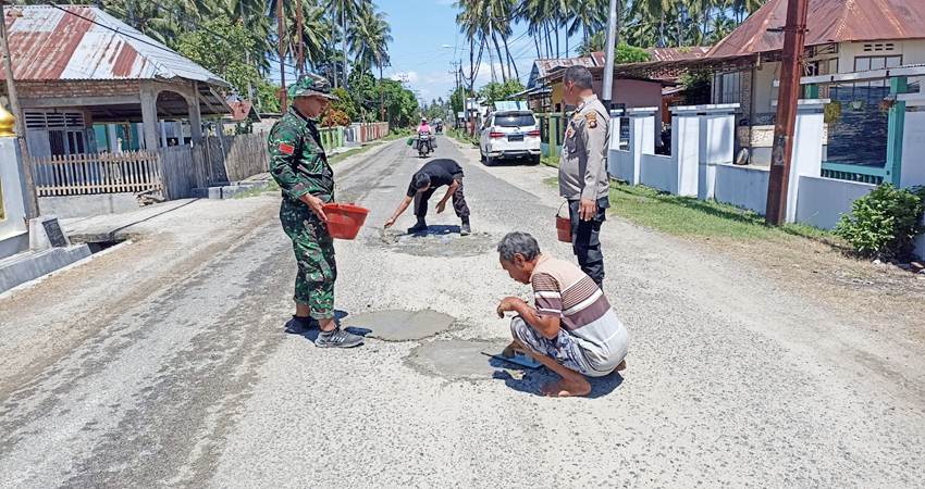 Personel Polsek Botupingge bersama Posramil Botupingge Koramil Suwawa serta warga setempat saat mengecor jalan rusak Pada Sabtu, (09/3/ 2024).