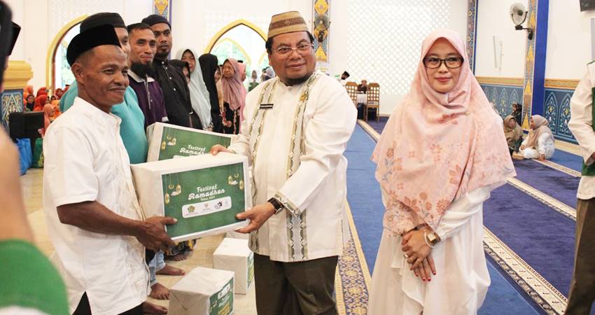 Kepala Kantor Kemenag Kabupaten Bone Bolango H.Sabara Karim Ngou menyerahkan paket sembako kepada warga pada pelaksanaan Festival Ramadhan 2024 Kolaborasi Sejuta Cinta.Jumat,(22/03).(Foto: Lidya /Gorontalo Post)