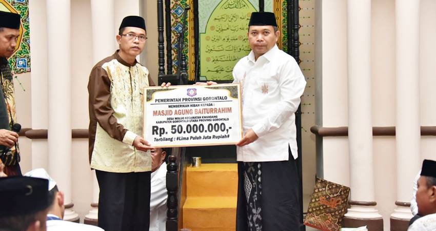 Penjagub Gorontalo Ismail Pakaya saat menyerahkan bantuan secara simbolis kepada takmirul masjid Agung Baiturrahim Gorontalo Utara, Kamis (21/3/2024). (Foto – Ryan /Diskominfotik)