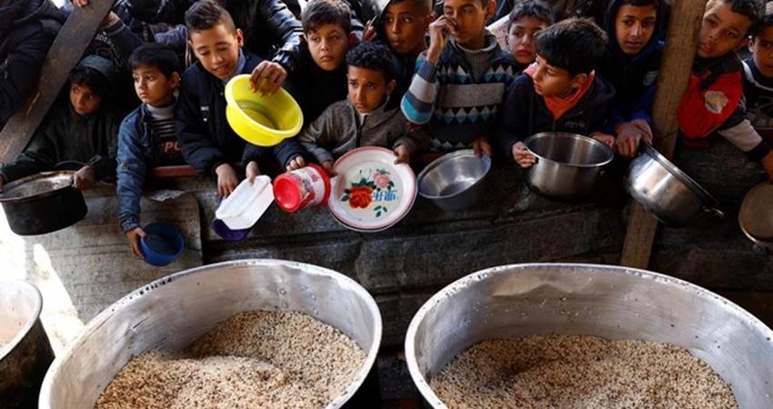 Anak-anak Palestina di Jalur Gaza yang tengah mengantre bantuan makanan pada Kamis (29/2). (REUTERS)