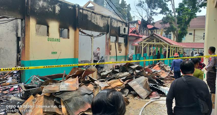 Petugas membersihkan puing kebakaran di salah satu gedung milik RS MM Dunda Limboto, yang terbakar, Senin (11/3).