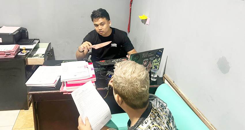 Penyidik Satreskrim Polres Gorontalo Kota saat memperlihatkan sajam jenis pisau dapur yang digunakan YS saat menikam ayah angkatnya