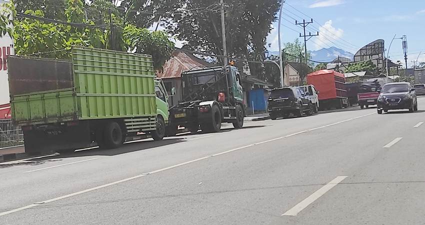 Antrian kendaraan jenis truk di SPBU Andalas hingga simpang tiga antara Jalan Tirtonadi dengan jalan John Aryo Katili. Kendaraan mengantri di dua bahu jalan sisi kiri dan kanan yang memicu terganggunga arus kendaraan. (Foto : Roy/Gorontalo Post).