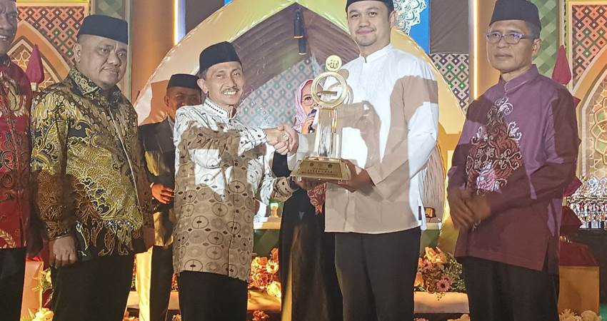 TUTUP. Bupati Gorontalo Nelson Pomalingo didampingi Wakil bupati Hendra S Hemeto saat memberikan tropi juara umum kepada Wakil Walikota Ryan Kono, didampingi Sekda kota Gorontalo Ismail Majid.