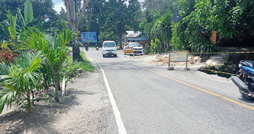 Hampir separuh badan jalan yang sudah ambrol dan dipagari menggunakan tali agar kendaraan tidak terperosok ke dalam lubang yang dalam. (Foto: Istimewa). INSERT ; Petugas Satlantas Polres Gorut saat memberikan pengumuman kepada masyarakat perihal penutupan jalan Pontolo.