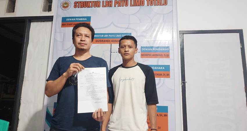 Dewan Pembina LBH Payu Limo Totalu, Muhamad Syarif Lamanasa didampingi asistennya memperlihatkan surat penetapan tersangka atas kliennya.