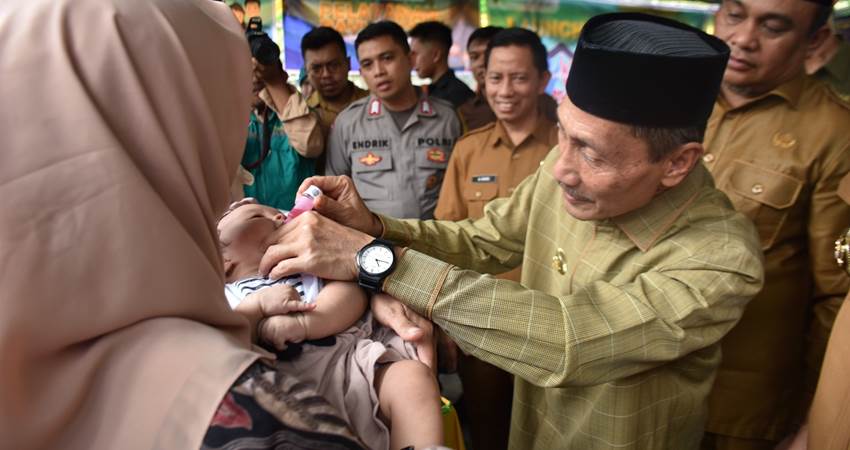 SIMBOLIS.Bupati Gorontalo Nelson Pomalingo saat memberikan vitamin pada salah seorang Balita yang hadir di Posyandu Sabar Menanti, Desa Huidu Utara Kecamatan Limboto Barat, senin (3/6). (F:Deice/Gorontalo Post