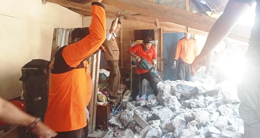 Petugas BPBD tengah menangani batu besar yang menimpa rumah warga di Kelurahan Tenda, Kecamatan Hulonthlangi, Kamis (18/7/2024). (Foto: Istimewa)