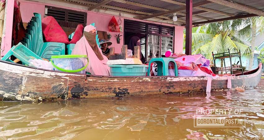 Warga di Desa Buhu kabupaten Gorontalo yang mengungsi menggunakan perahu.(Foto: DeiCe PoMalinGo / Gorontalo Post)