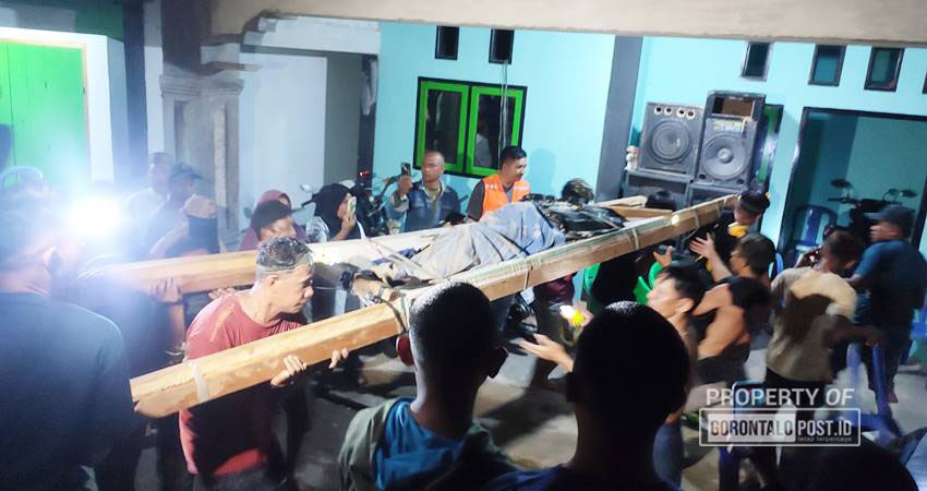 KORBAN : Korban longsor tambang suwawa yang meninggal dunia, tiba di rumah duka dari lokasi tambang setelah dievakuasi dengan ditandu, Ahad (7/7) malam. (foto :natha / Gorontalo Post)