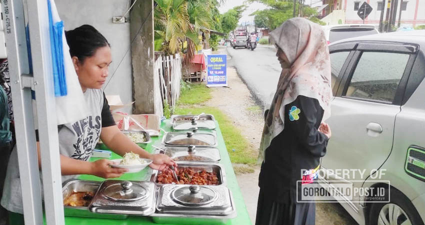 Penjual makanan sepat saji di Kelurahan Wongkaditi Kecamatan Kota Utara, Kota Gorontalo yang kebanjiran orderan saat banjir selama beberapa hari terakhir, Kamis, (11/7/2024). (Foto: Roy/Gorontalo Post).