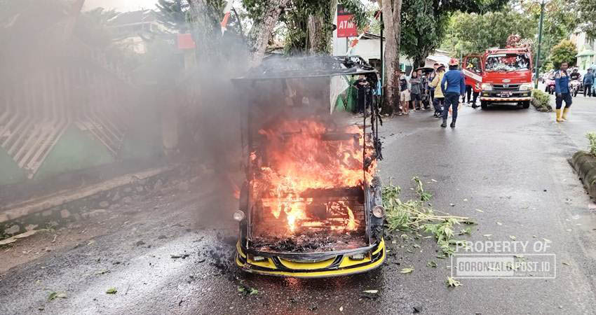 Sebuah bentor yang terparkir, tiba-tiba mengeluarkan api dan berusaha dipadamkan oleh petugas Damkar Kabupaten Gorontalo. (F. Deice/ Gorontalo Post)