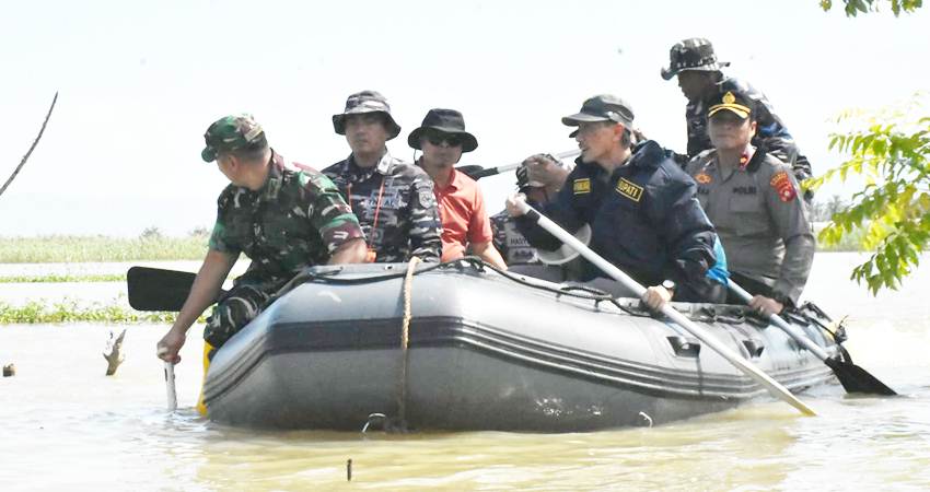 TINJAU. Bupati dan jajaran Forkopimda saat turun kembali melihat warga terdampak banjir dengan naik perahu.