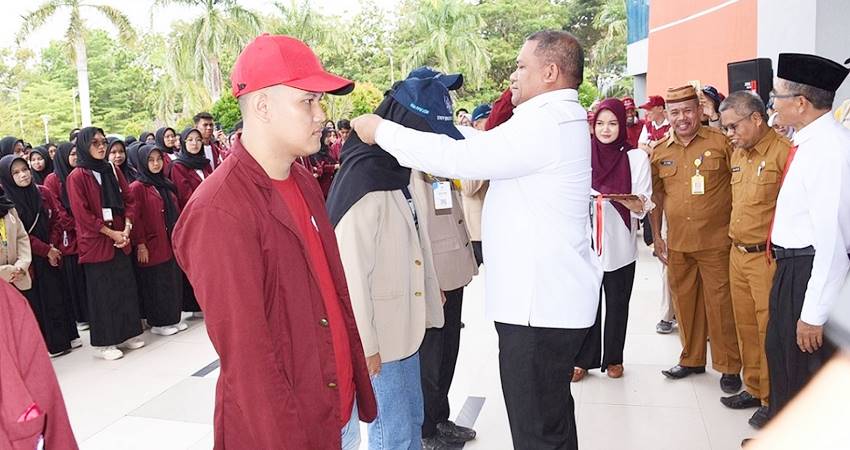 Rektor UNG Prof. Eduart Wolok menyematkan tanda peserta mahasiswa KKN dari UGM kolaborasi UNG, Senin (1/7). (foto : dok / ung)