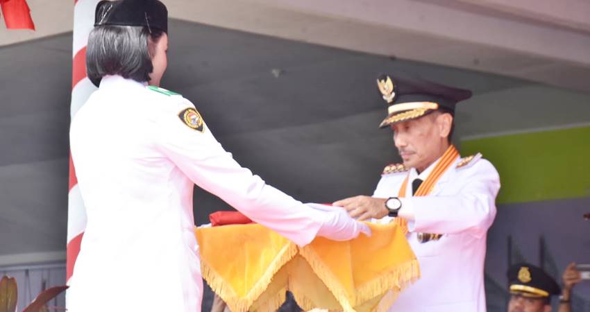 Bupati Gorontalo Nelson Pomalingo saat menyerahkan bendera pusaka pada petugas PASKIBARAKA untuk dikibarkan, pada upacara pengibaran bendera