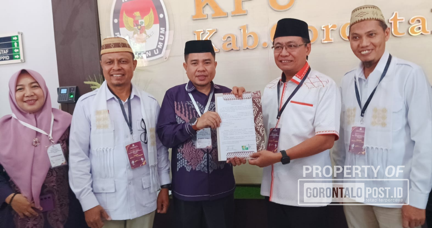 PENYERAHAN. Ketua KPU Roy Hamrain saat menyerahkan dokumen hasil verifikasi pada pasangan Calon Bupati Roni Sampir dan Calon Wakil Bupati Adnan Entengo. (F:Deice/Gorontalo post)