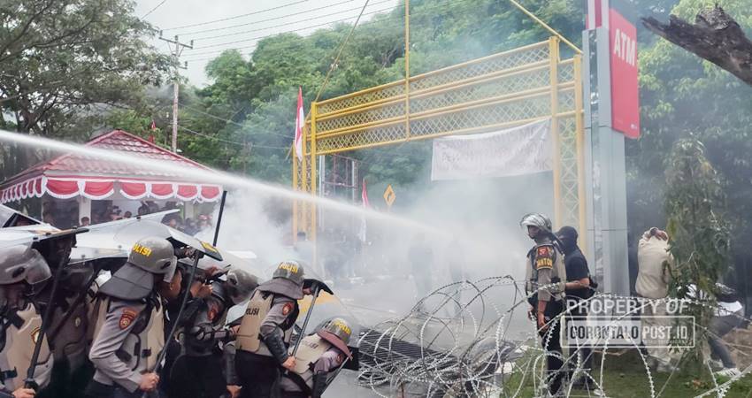 PERINGATAN DARURAT : Petugas menyemprotkan air bertekanan tinggi kepada mahasiswa yang melakukan aksi menolak pengesahan revisi UU Pilkada oleh DPR RI di kantor DPRD Provinsi Gorontalo, Jumat (23/8). Aksi penolakan serupa melalui media sosial ditandai dengan gambar Garuda berlatar biru, bertuliskan Peringatan Darurat. (foto : natha / gorontalo post)