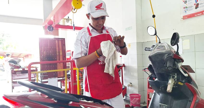 PROFESIONAL : Teknisi bengkel resmi Honda, Astra Honda Authorized Service Station (AHASS) melakukan service sepeda motor honda. (foto : dok /daw)
