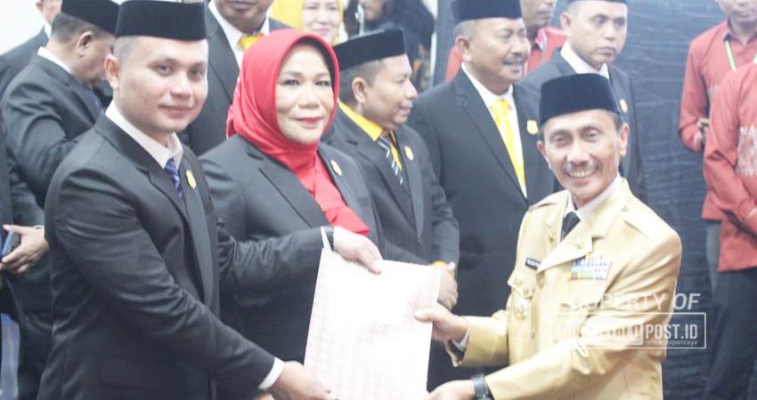 SERAHKAN. Bupati Gorontalo Nelson Pomalingo saat memberikan surat keputusan pada dua aleg secara simbolis. (F”Deice/Gorontalo Post)