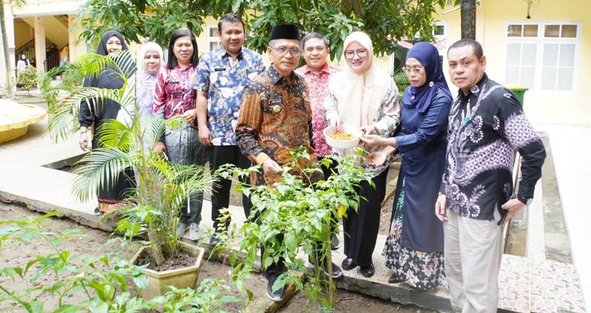 Pj Wali Kota Gorontalo, Ismail Madjid bersama sejumlah pejabat tengah memanen cabe yang ditanam di lahan pekarangan kantor wali kota. (Foto: Istimewa)