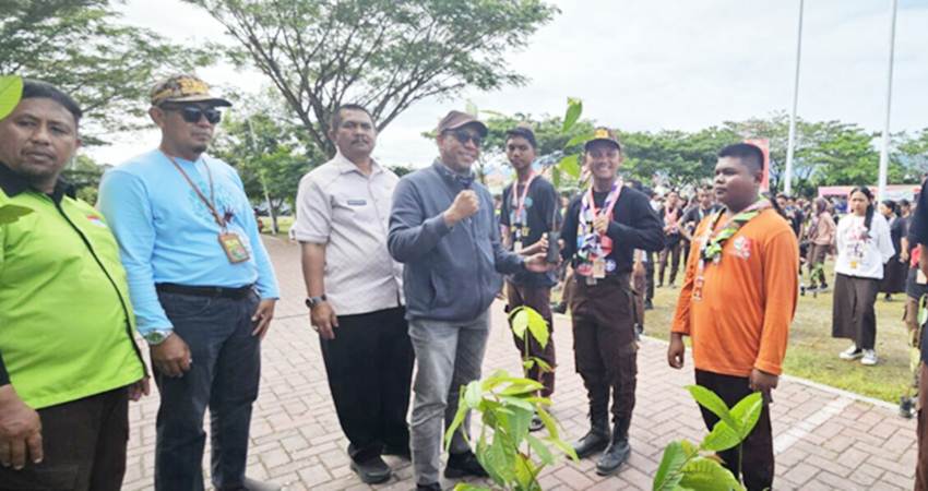 CINTA ALAM : Ketua Panitia Kemah Bela Negara, Rudi Daenunu, dan Wakil Ketua Kwarda Bidang Orgakum, Sumarto Biki, menyerahkan bibit pohon buah kepada peserta kemah bela negara untuk ditanam di alun-alun Bone Bolango, dan sekitarnya, Jumat (23/8). (foto : dok / kwarda gorontalo)