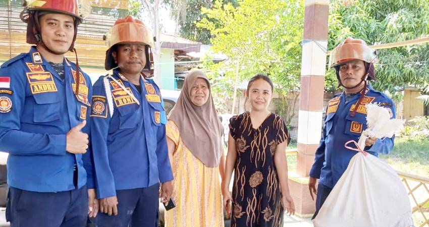 Tiga petugas bersama pemilik rumah seusai menangkap biawak.