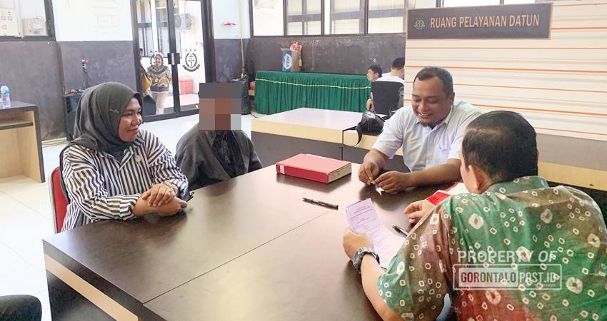 Kanit PPA Satuan Reskrim Polres Gorontalo Utara, Aipda Eris Novianto,S.H,M.H saat menyerahkan tersangka dan barang bukti kepada pihak Kejaksaan Negeri Gorontalo Utara, Jumat (6/9). (F. Zulkifli/ Gorontalo Post)