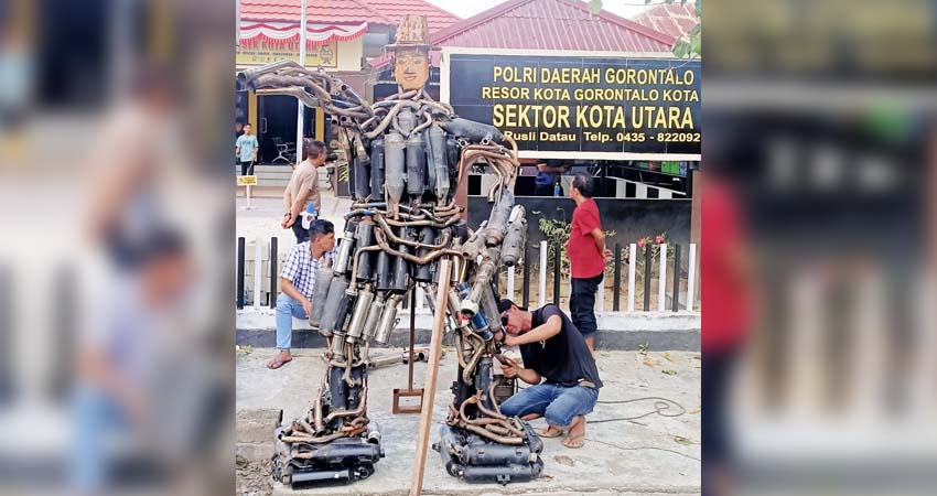 Kapolsek Kota Utara beserta personel saat membangun patung robot dari knalpot brong, yang merupakan hasil razia selama kurang lebih tiga bulan lamanya.