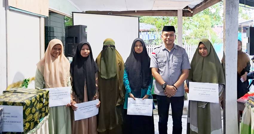 Camat Sipatana Lukman Laisa menyerahkan bingkisan kepada anak Yatim piatu di momen Milad ke 1 Rumah Quran Al Yasiir Gorontalo baru-baru ini. (Foto: Istimewa).