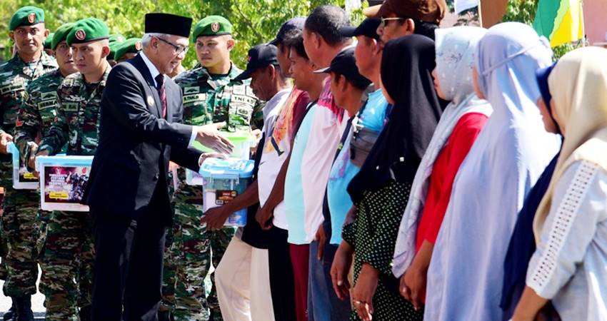 Pj. Gubernur Gorontalo, Rudy Salahuddin, menyerahkan bantuan kebutuhan pokok pada peringatan HUT ke-79 TNI di lapangan David-Tony Limboto, Kabupaten Gorontalo, Sabtu (5/10/2024). (Foto : Haris)