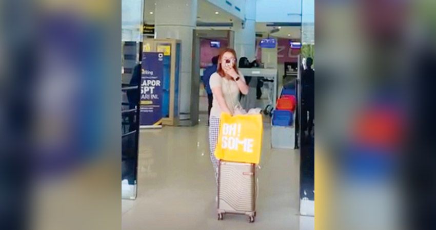 Sri Meyke Male masih sempat memotret keluarganya dengan kamera handphone sebelum masuk ke gedung terminal Bandara Djalaludin Gorontalo, Ahad (20/10). (foto : tangkapan layar)