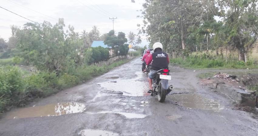 Lubang besar yang dipenuhi air hujan tampak mengangah dan rawan kecelakaan. (Foto: Roy/Gorontalo Post).